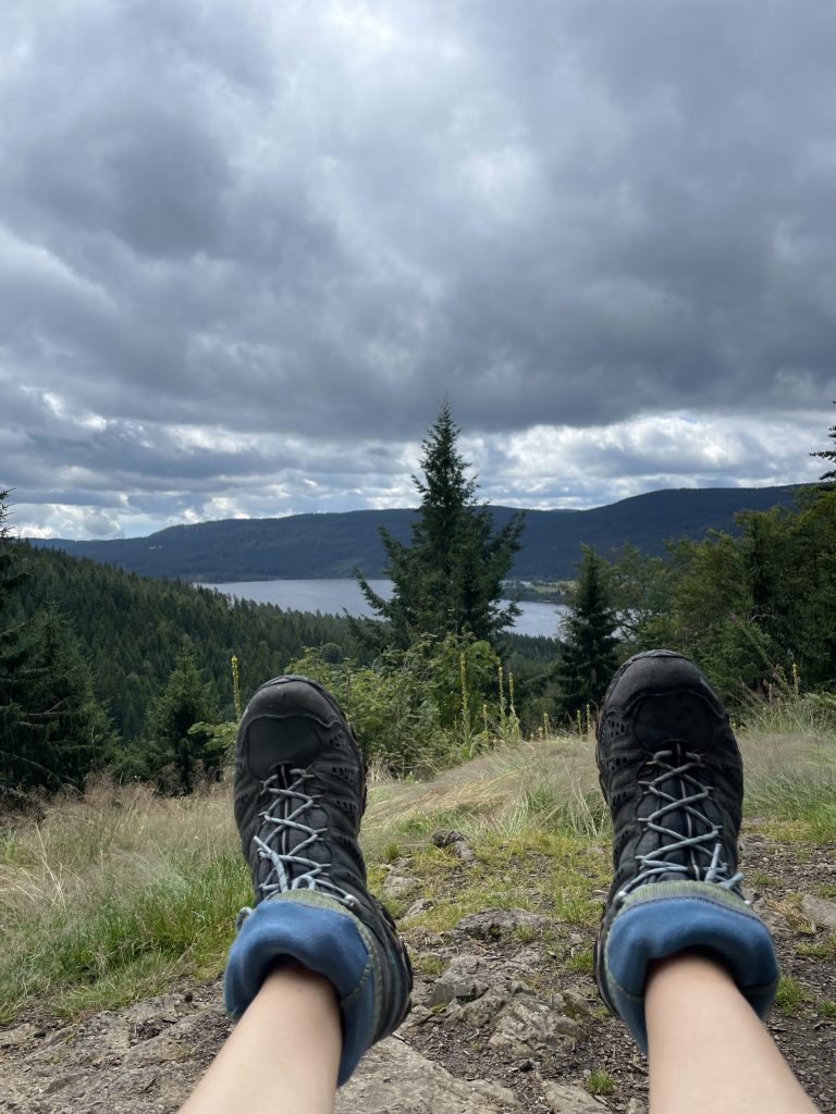 Füße in Wanderschuhen mit Blick auf den Schluchsee